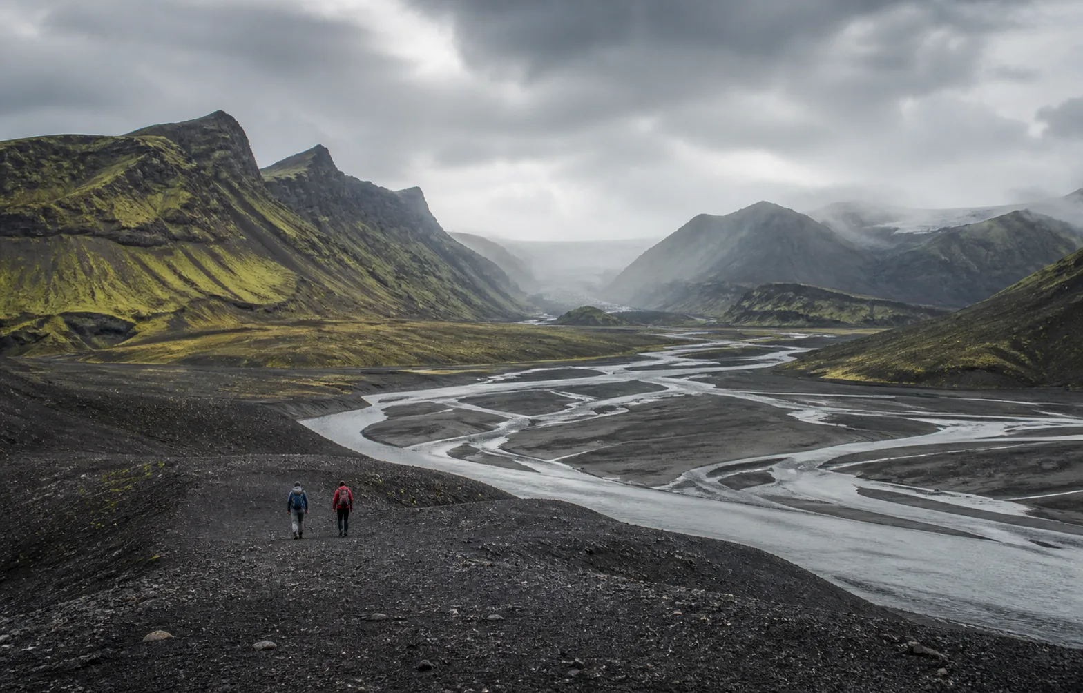 Hikers crossing a volcanic valley in Iceland